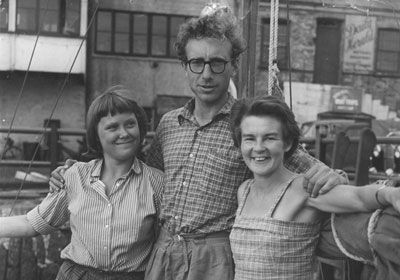 A man with his arms around two women