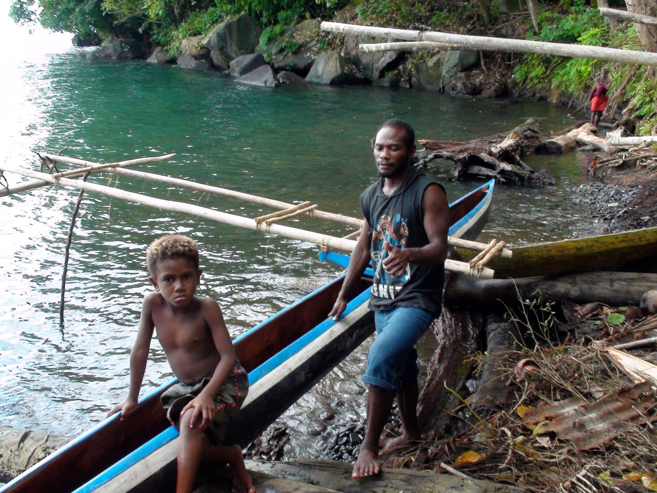 Locals with an outrigger canoe on the shore