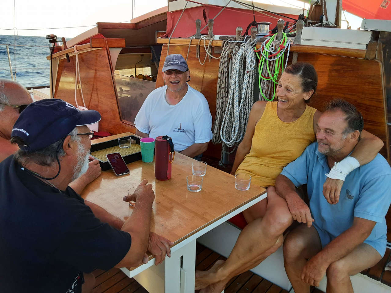 Crew members sat around the table on deck, smiling and laughing