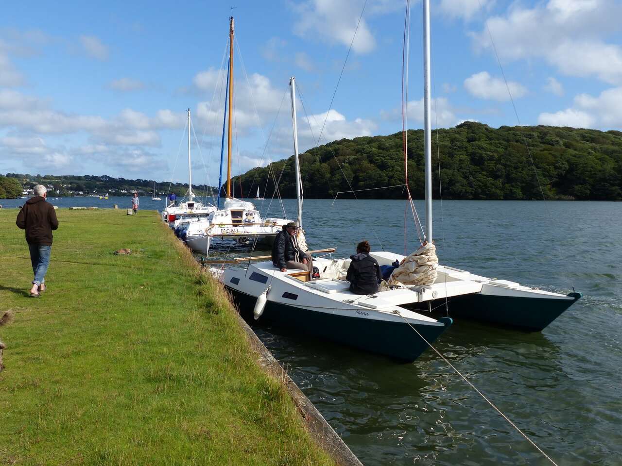 Catamarans moored at a grassy quay