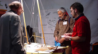 James and two others studying a boat model