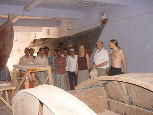 Workshop with Tiki 38 hulls under construction, people stood in front
