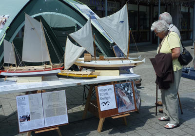 People studying boat models on a stand