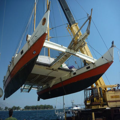 Large catamaran being lifted by crane
