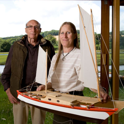 Two people in a design studio posing with a boat model