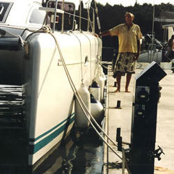 A man standing next to a catamaran