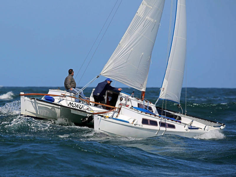 A catamaran riding down a wave