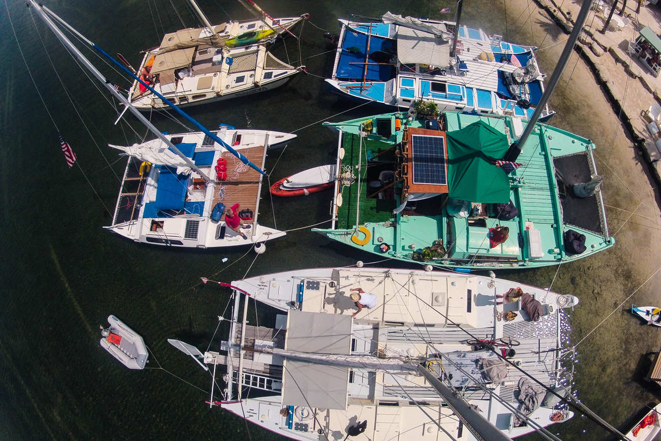 Aerial view of 5 colourful Wharram catamarans at the beach