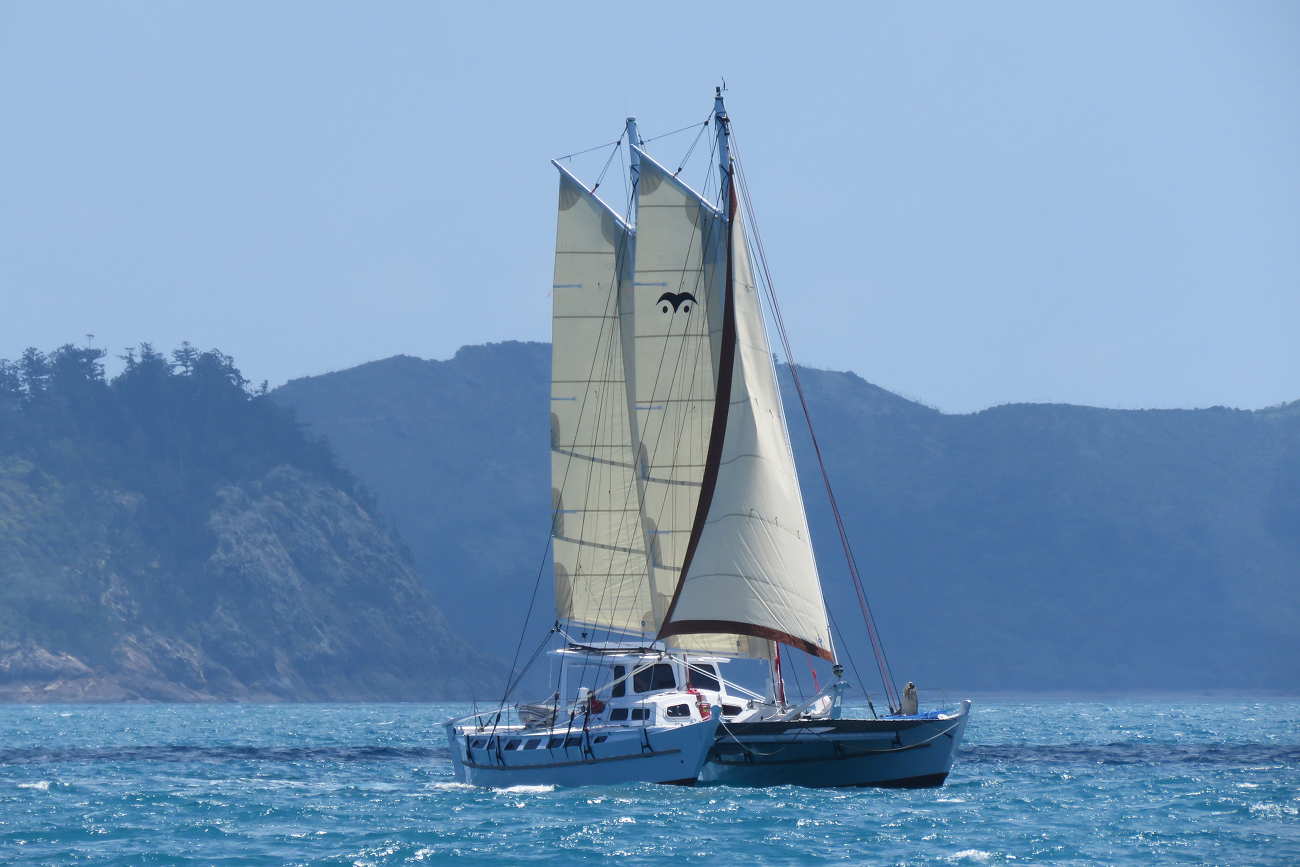Distant photo of Wharram Tiki 46 on the water with all sails up