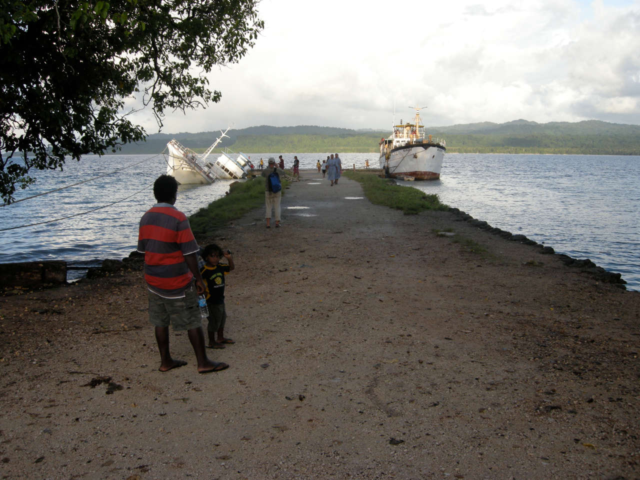 A wharf with people on it and a ship docked