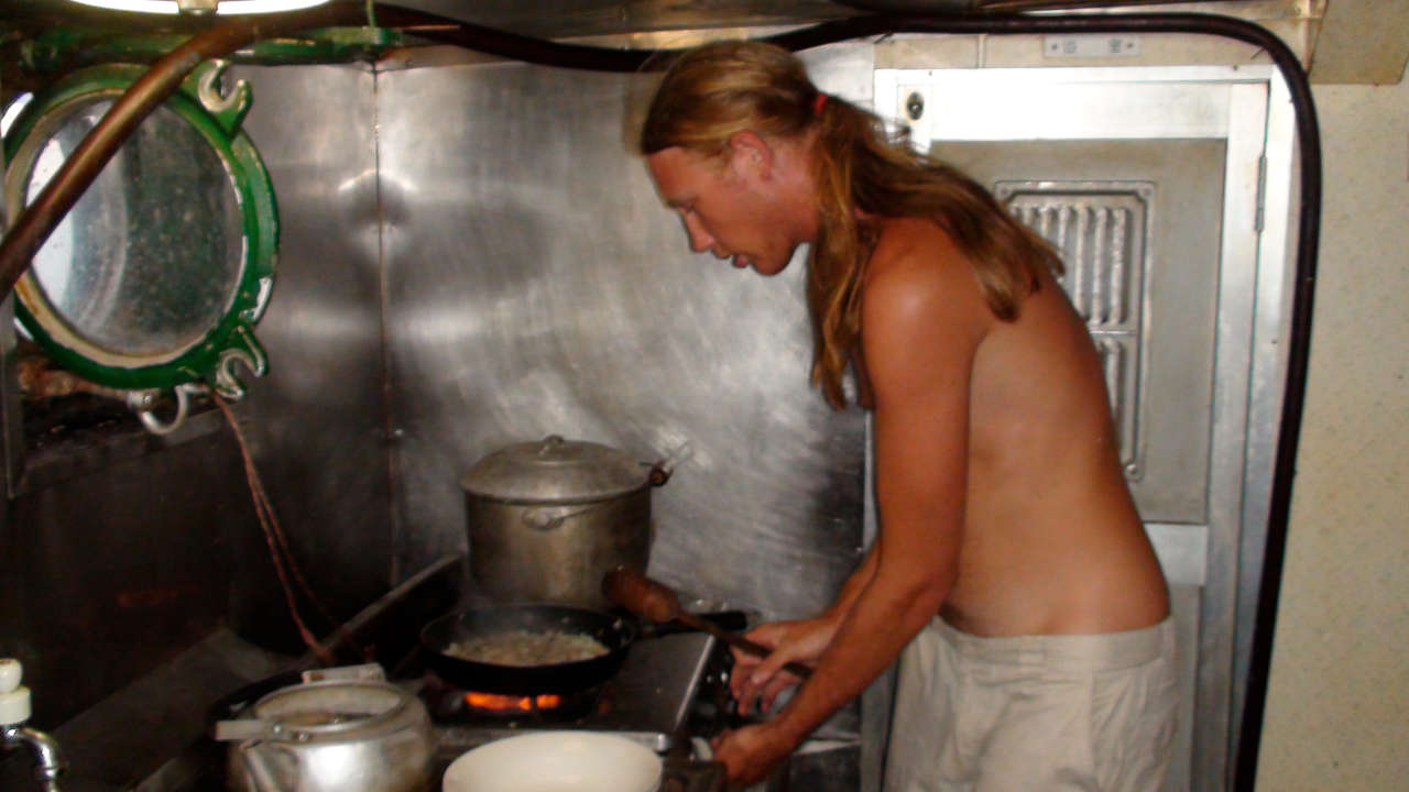 A man cooking in a galley