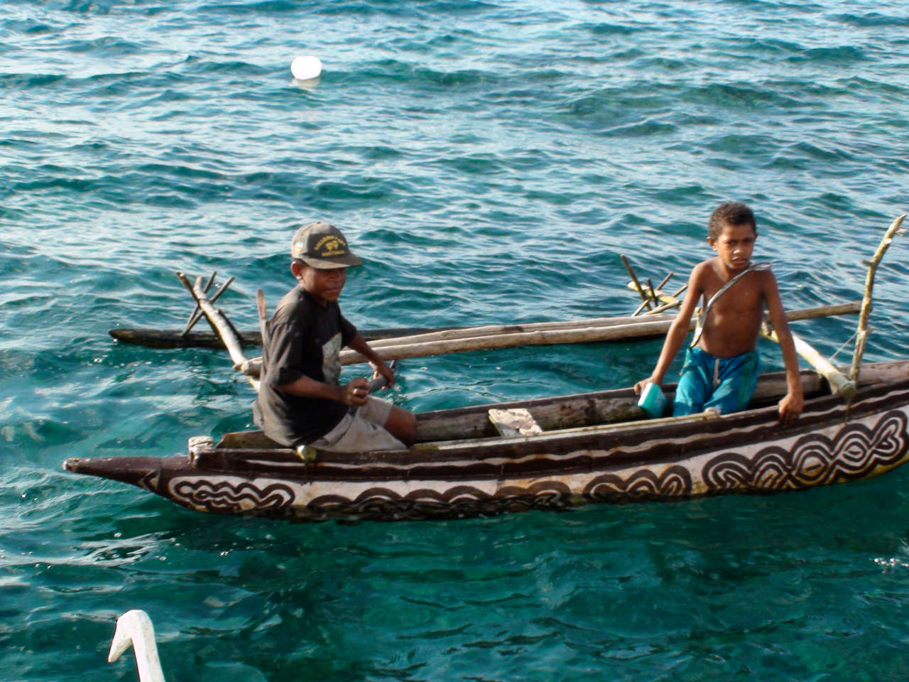 Local children in an outrigger canoe