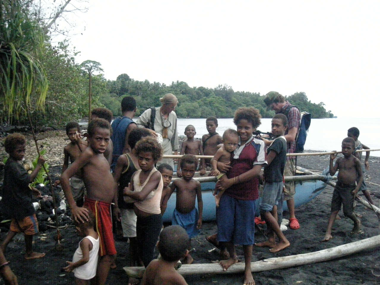 Hanneke surrounded by children, examining an outrigger canoe