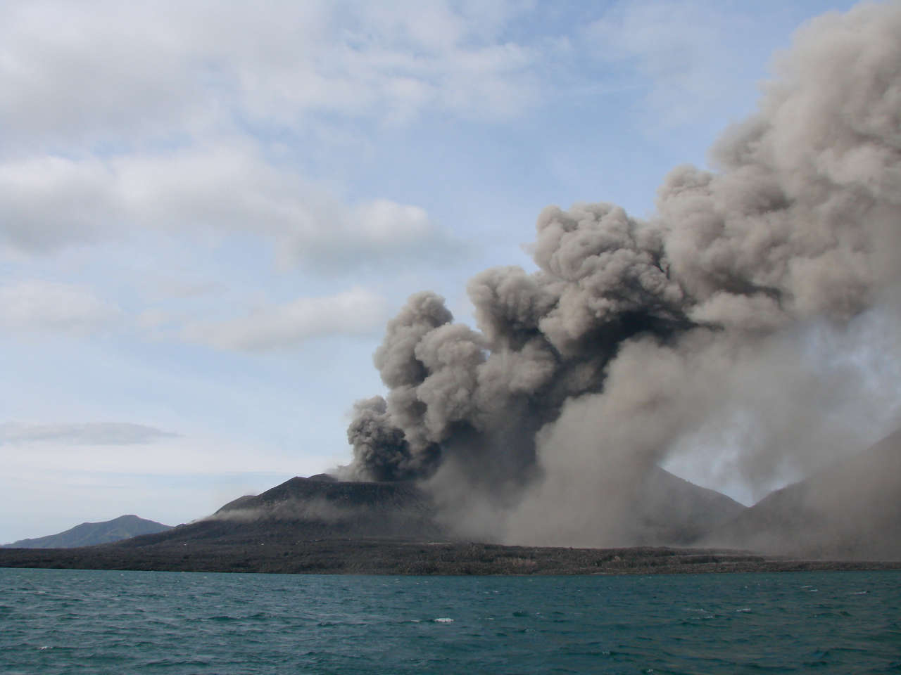 Smoke and ash from a volcano, viewed from the sea