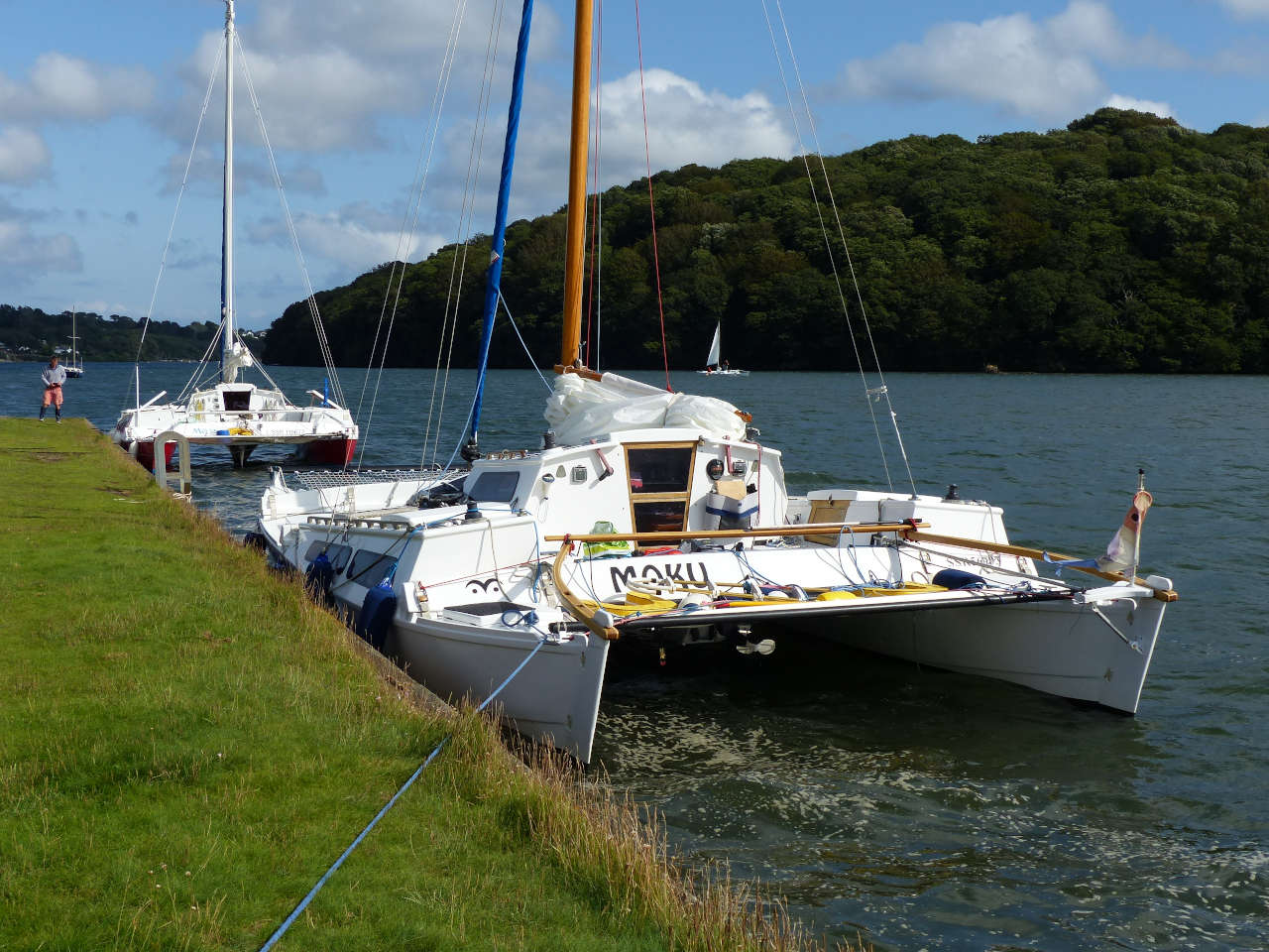 Two catamarans on a quayside, treees in background