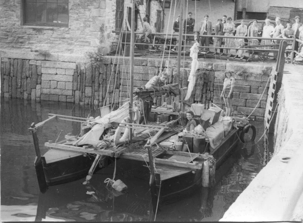 Old black and white photo of a catamaran moored in a harbour