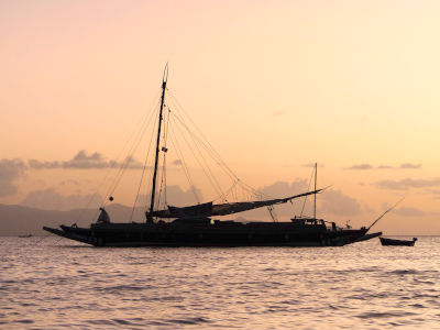 Double sailing canoe at sunset