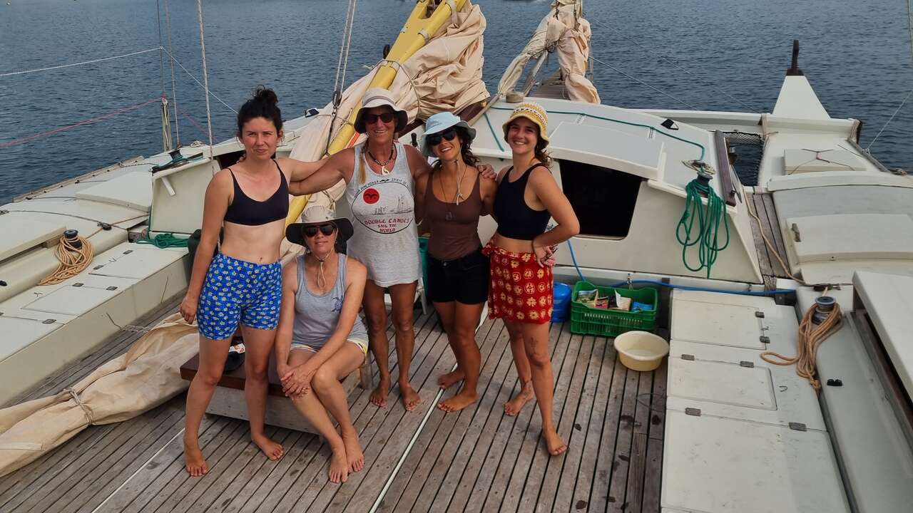 Five women on a catamaran posing for a photo