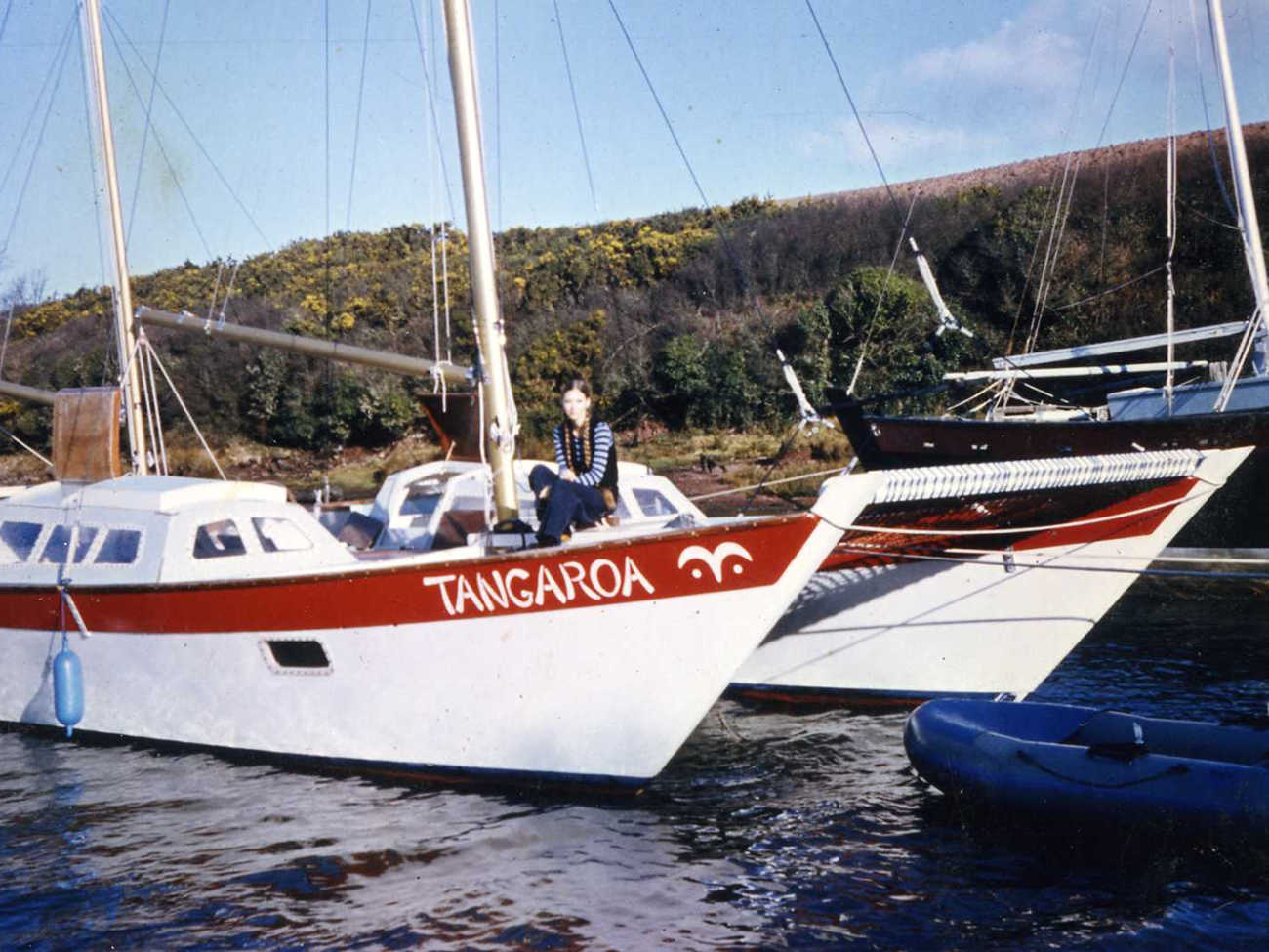 Tangaroa at anchor, eye symbol painted on hull, one woman aboard