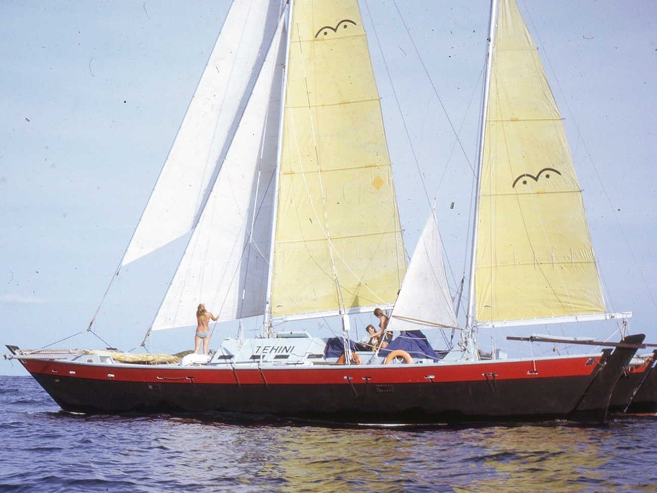 Red and black hulled Tehini with yellow sails, view from the starboard bow