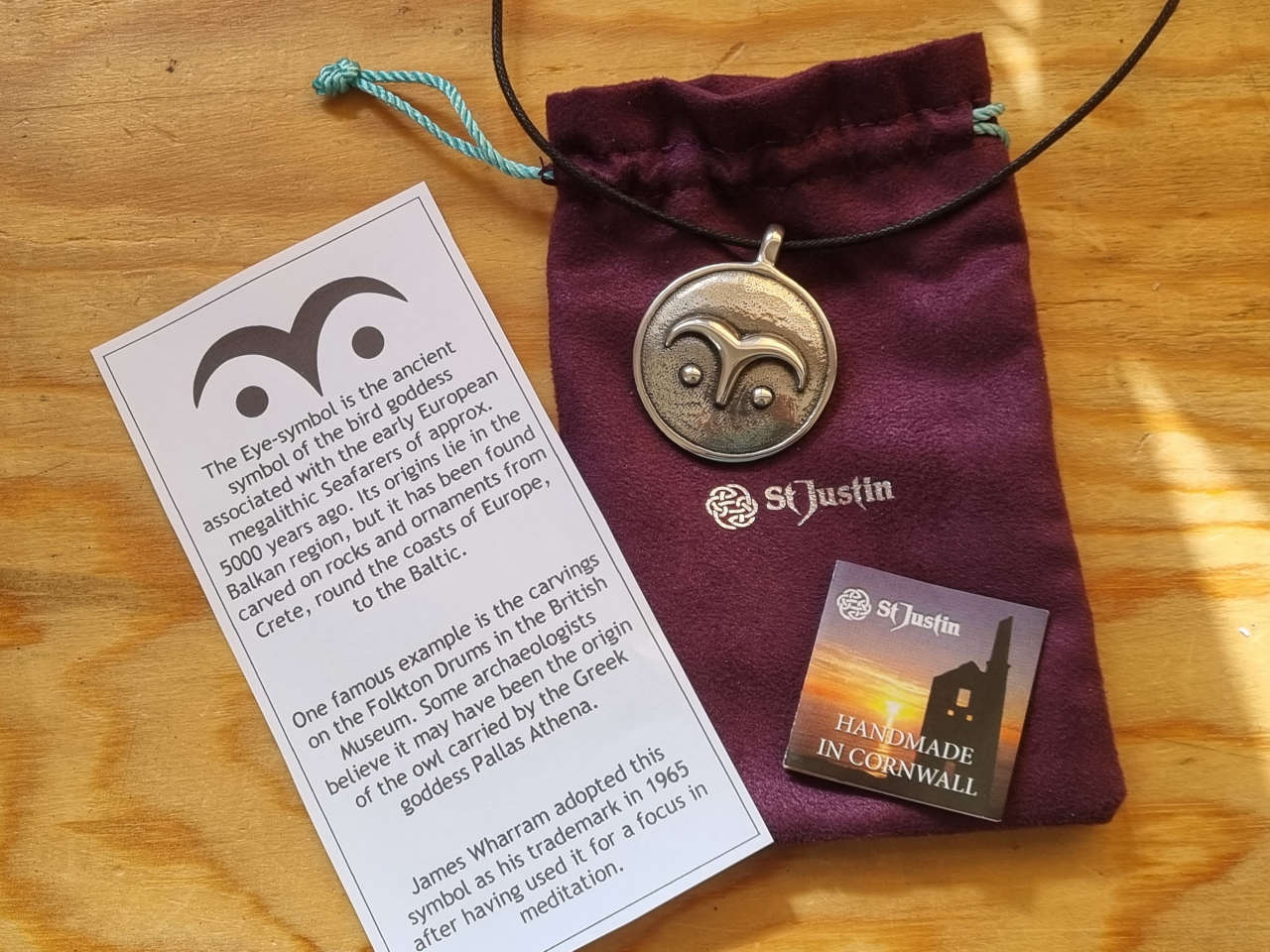 Eye symbol pendant with purple pouch, small booklet and a leaflet