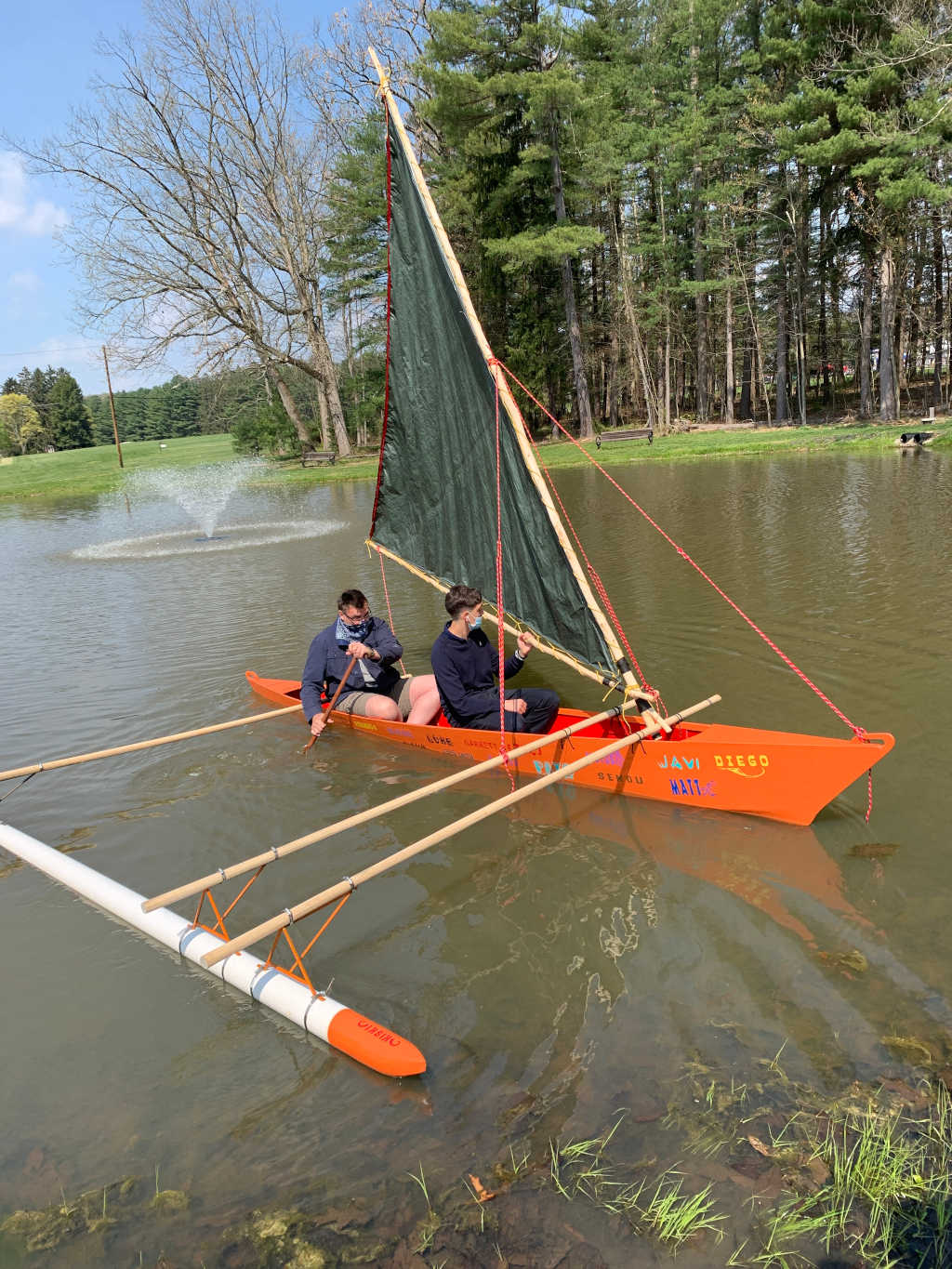 Outrigger canoe on the pond, crewed by two