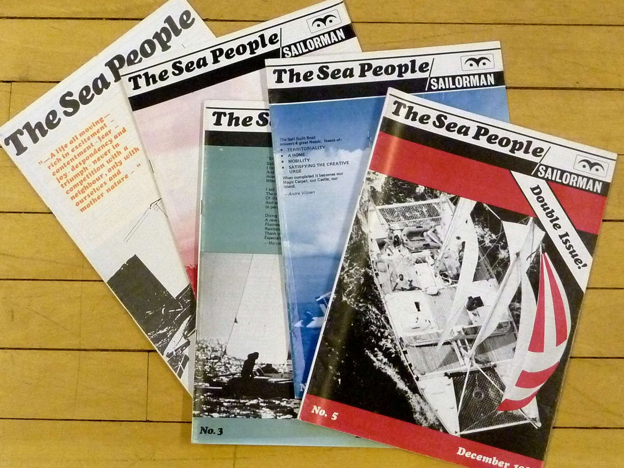 Five magazines spread out on a wooden surface, titled 'The Sea People'