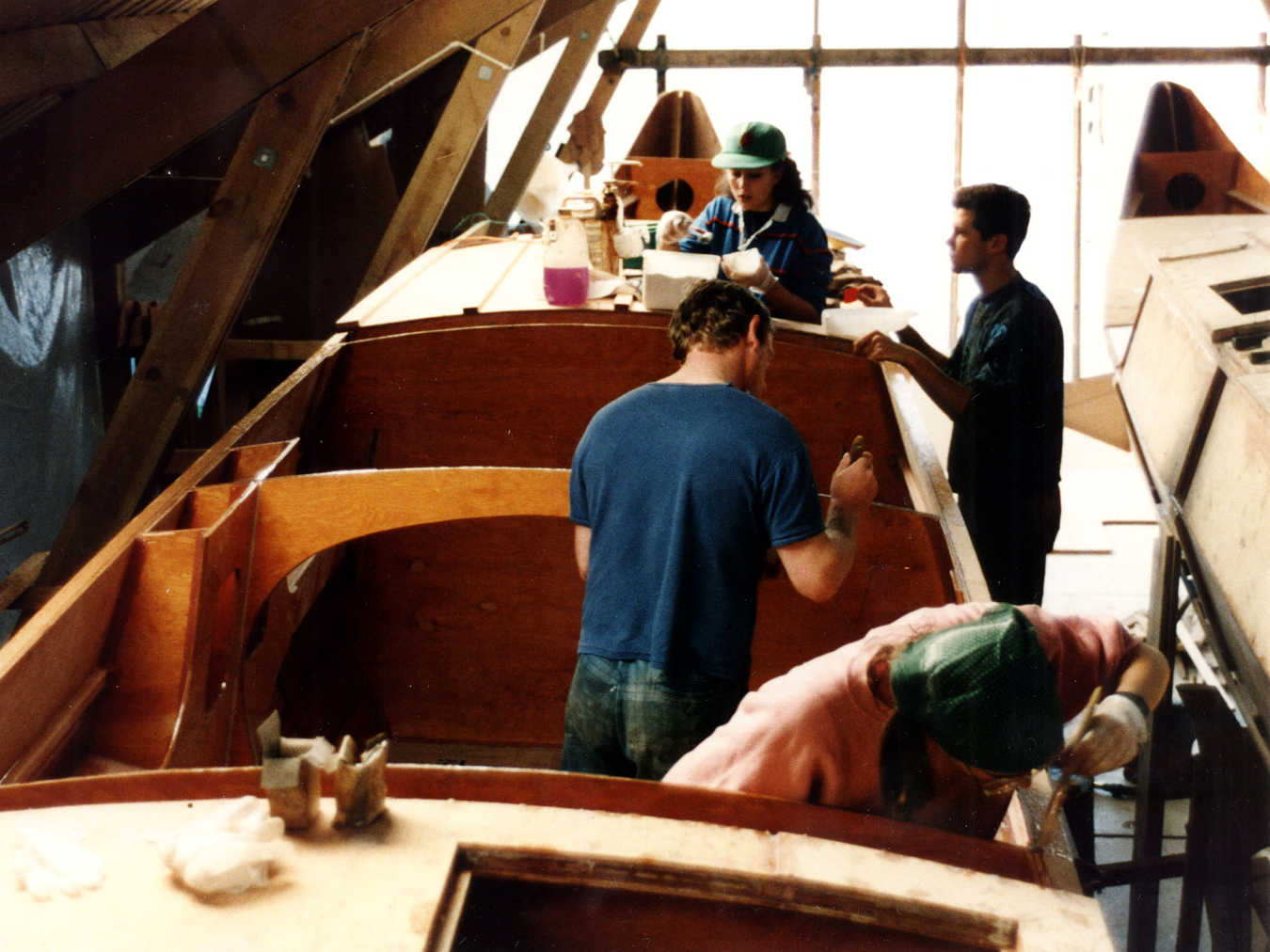 Builders working on a partially constructed catamaran hull