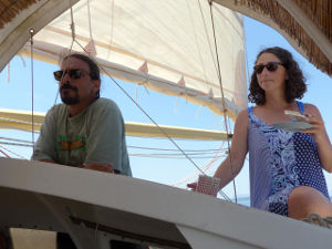 Shawn and Casey on deck, sails behind them