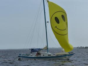 Wharram cat with smiley face spinnaker