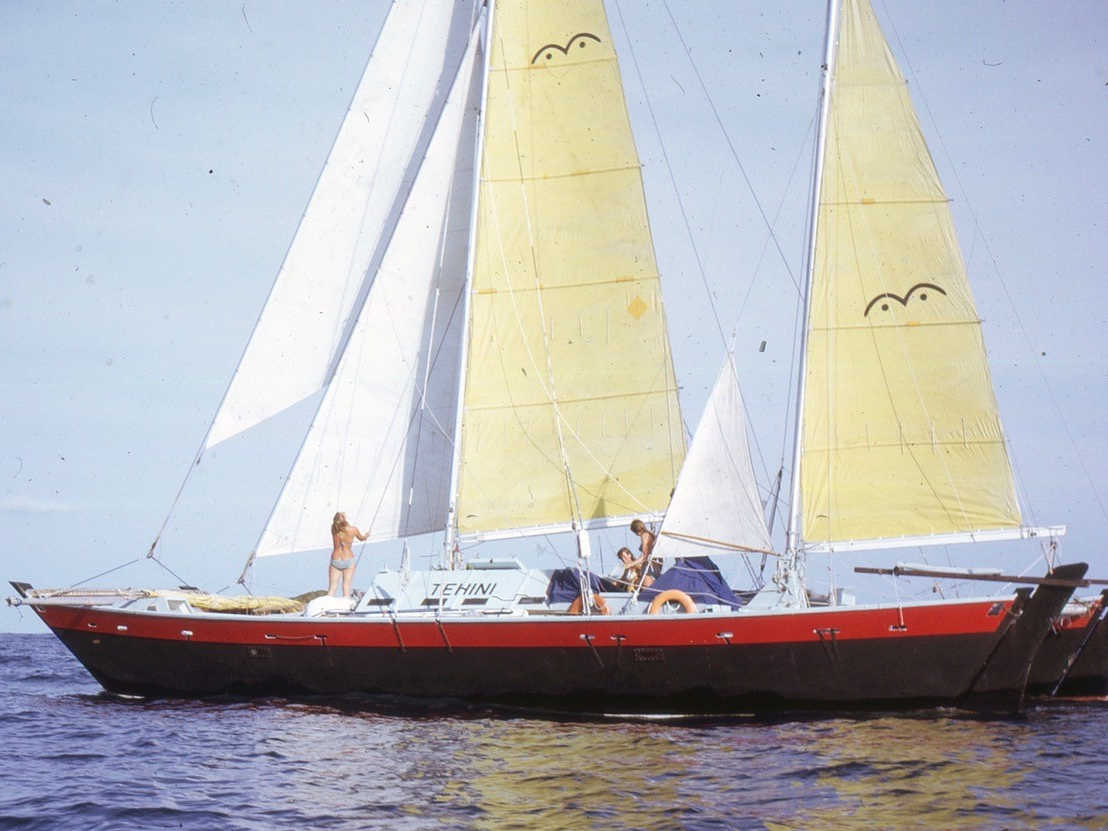 Red and black catamaran with sails up