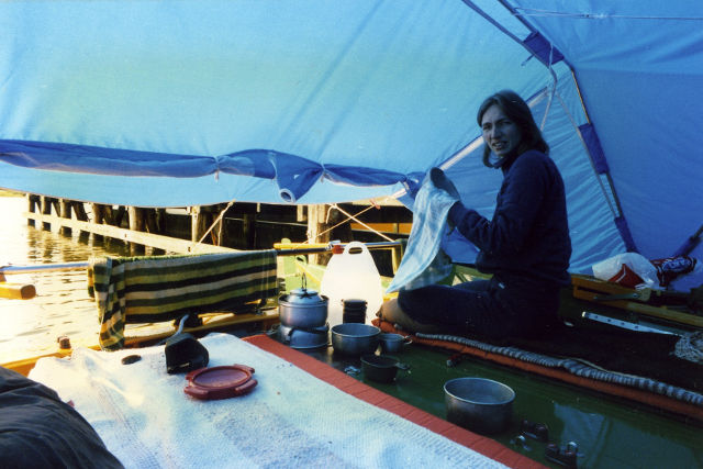 A woman under a decktent on a boat