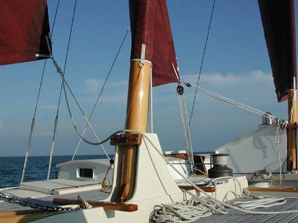A mast with red sails on a catamaran