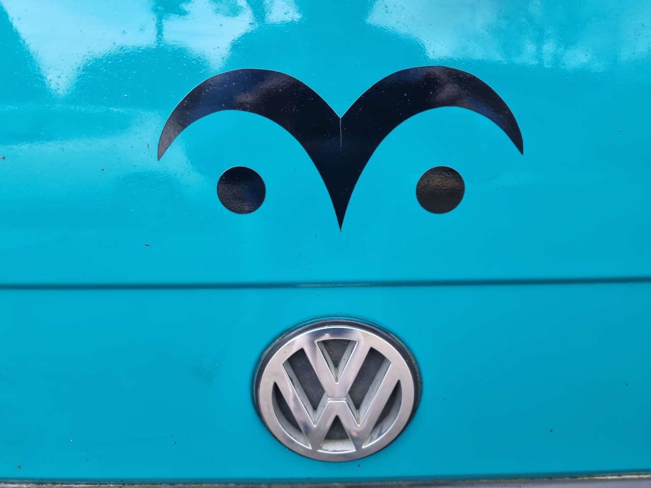 Eye symbol logo with VW logo beneath it