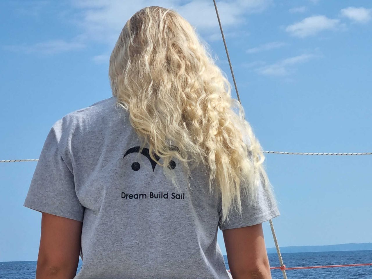 Rear view of woman with blonde hair and grey T-shirt