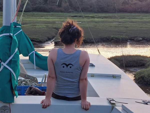 A girl wearing a tank top sitting on a boat